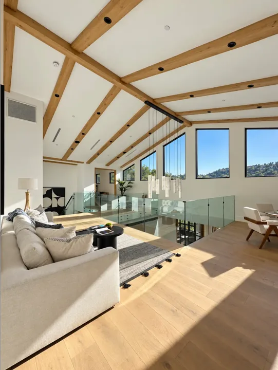 Living room with exposed wood beams and tall windows
