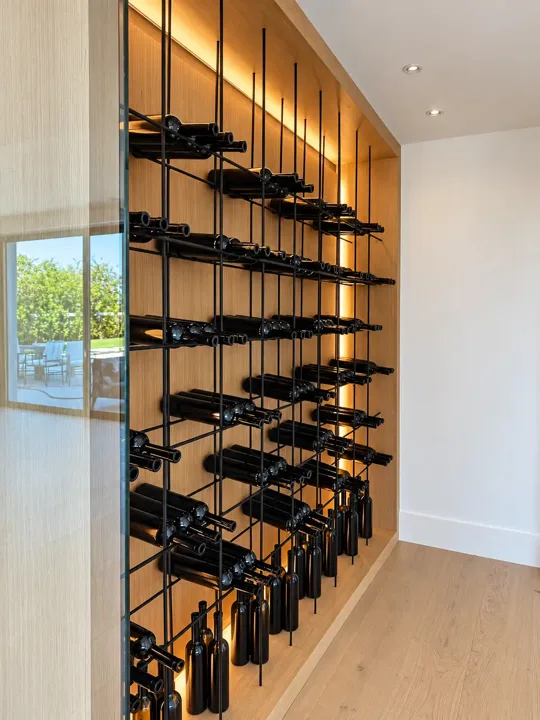 Glass-enclosed wine storage with black bottle racks