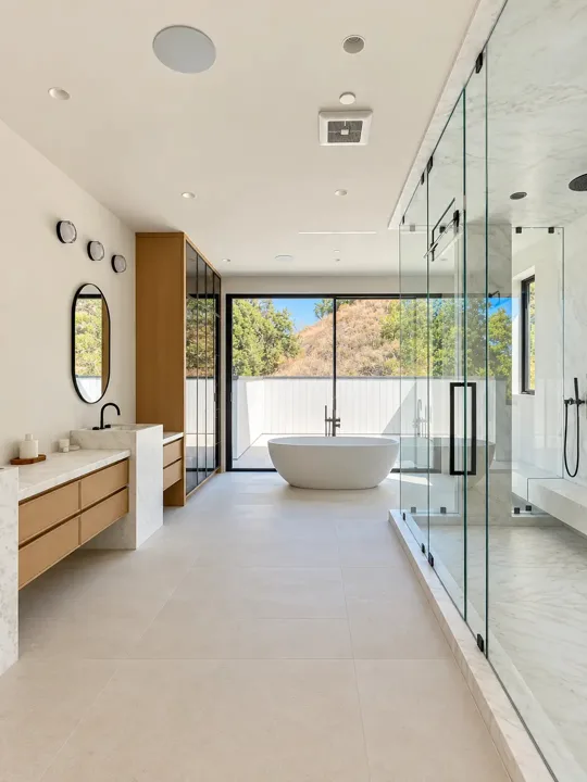 Freestanding tub and oak vanity in a light-filled bathroom