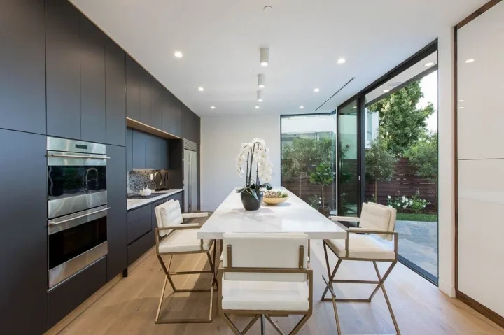 Dark kitchen cabinetry with an island beside garden-facing windows