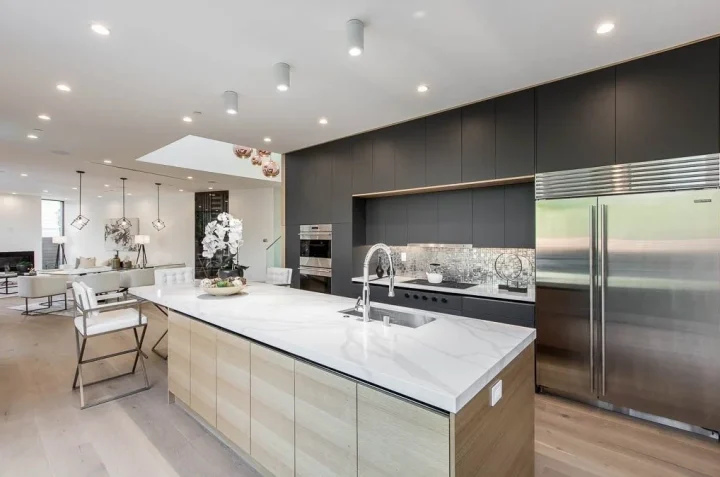 Stone kitchen island with dark cabinetry and stainless steel appliances