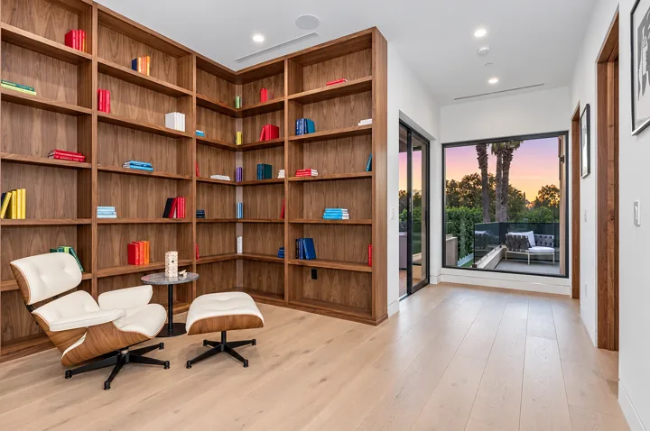 Tall oak library shelves surrounding a reading lounge