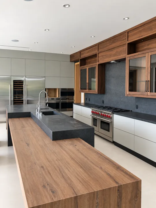 Kitchen with dark stone counters and integrated wood shelving