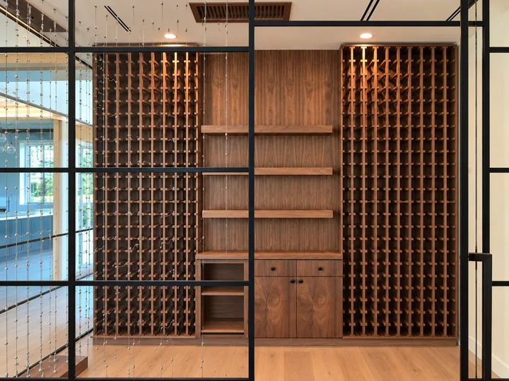 Glass-front wine room with full-height wood bottle racks