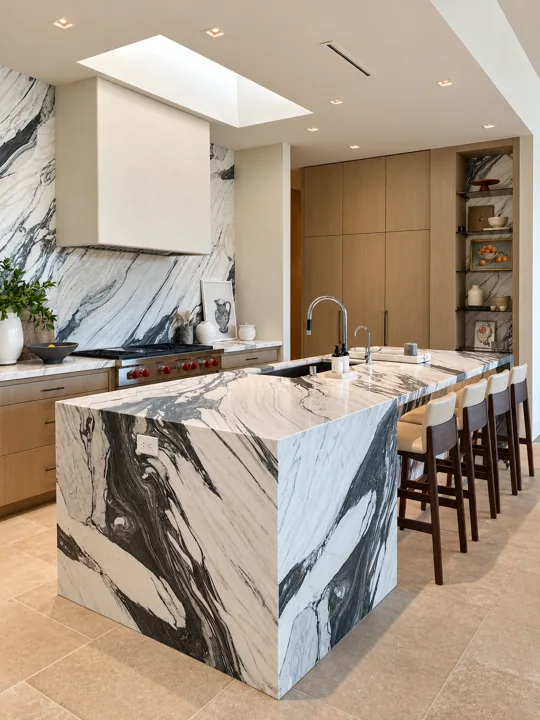 Veined marble kitchen island and backsplash with oak cabinetry
