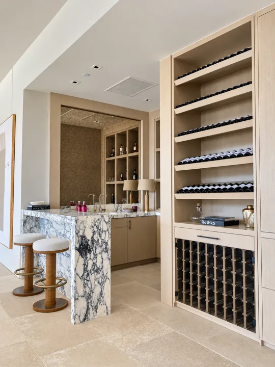 Oak bar shelving with marble counters and bottle storage
