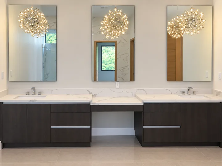Double vanity with pendant lights and dark cabinetry