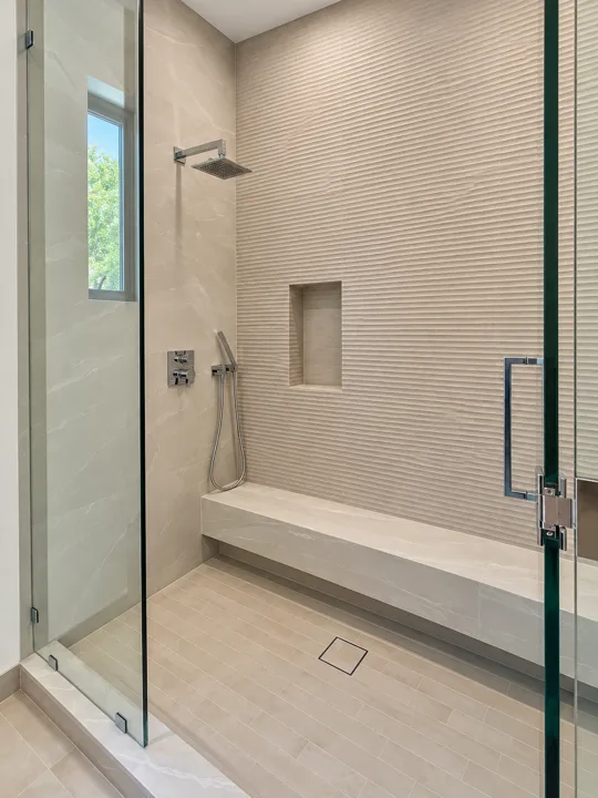Shower with textured tile and a recessed wall niche